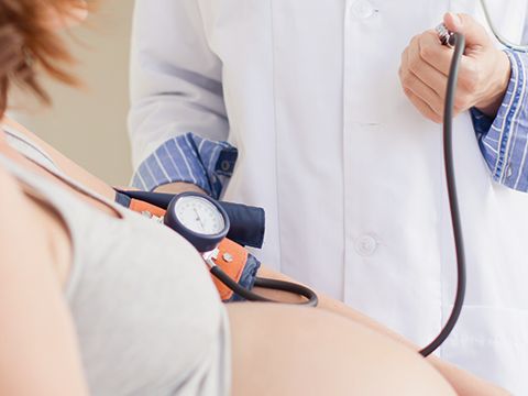 Arzt misst Blutdruck einer Schwangeren