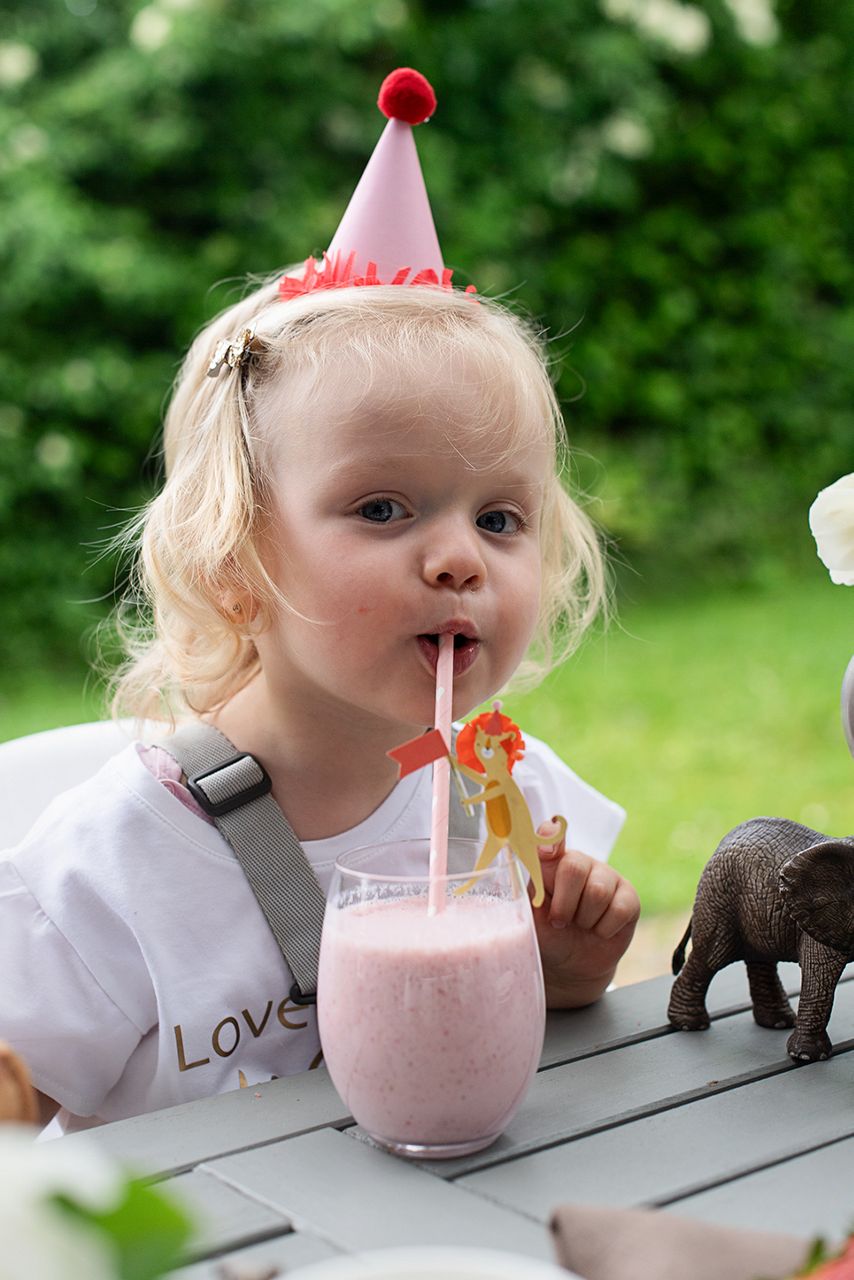 Kleines Mädchen trinkt Erdbeer Kindermilch