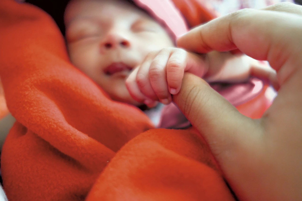 Mom holding baby hand