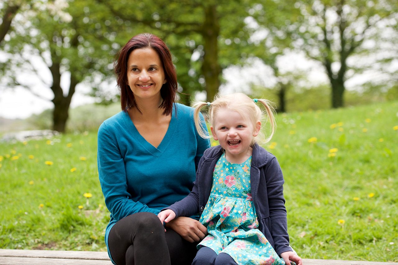Mother and daughter sitting on bench