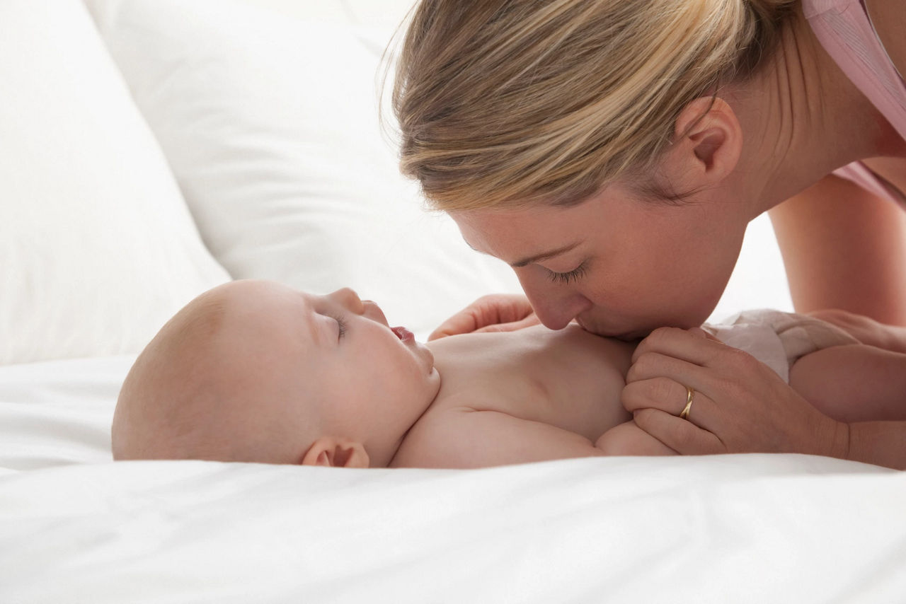 mother kissing baby tummy