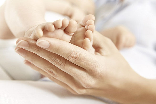 mother kissing babys feet