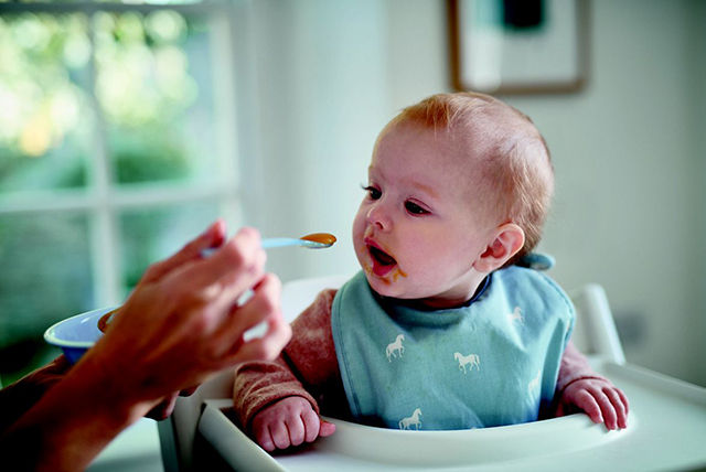 mother spoon feeding toddler 1