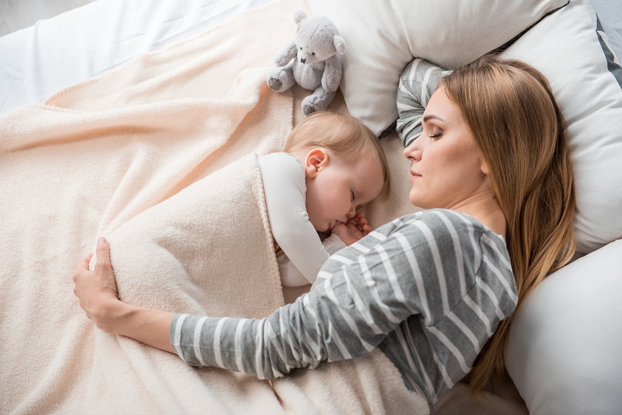 Top view of peaceful mother and cute child lying on double bed. They are sleeping together with tranquility getty images 900589316