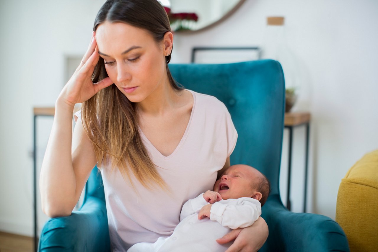 Stressed Mother Holding Crying Baby Suffering From Post Natal Depression At Home getty images 1143246023