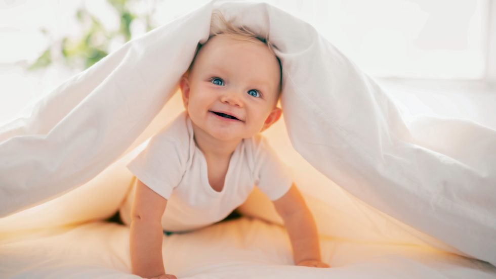 Lächelndes Baby unter einer Decke