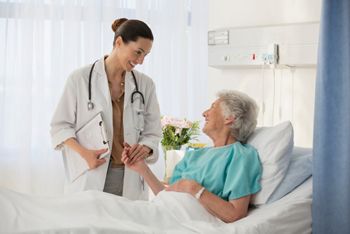 Doctor and senior patient talking in hospital room