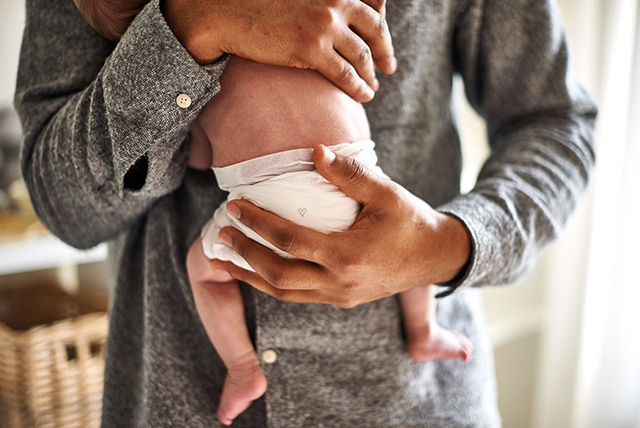 newborn baby hugging father