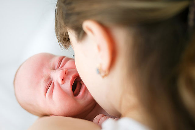 newborn crying in mothers arms