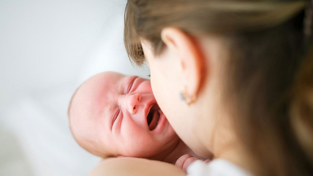 Bebe recién nacido llorando en brazos de su madre, simbolizando el llanto como la primera forma de comunicación del bebé