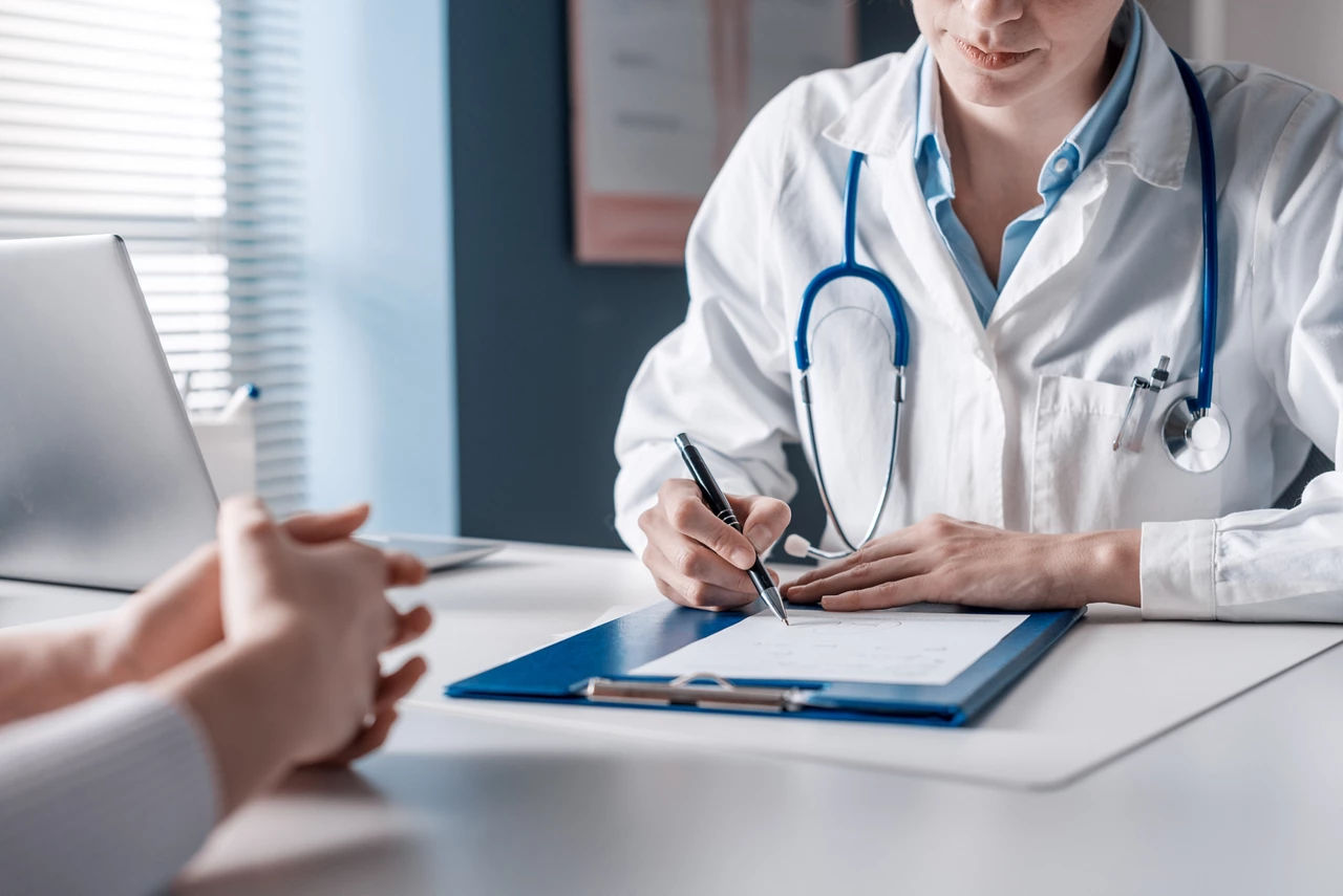  GP sitting at the desk an filling a prescription