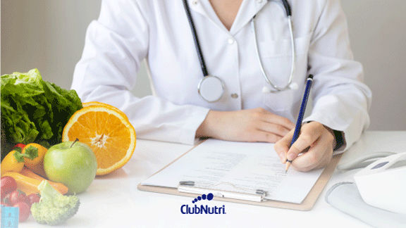 medico nutricionista sentado en escritorio con frutas y verduras