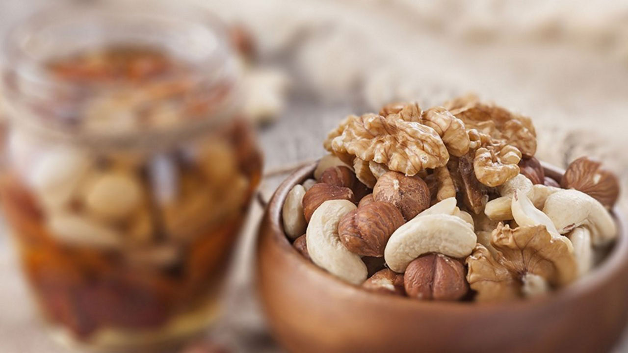 Cuenco de frutos secos variados, incluyendo nueces, avellanas y anacardos: Comida sólida para bebés: frutos secos como opción nutritiva al introducir alimentos sólidos