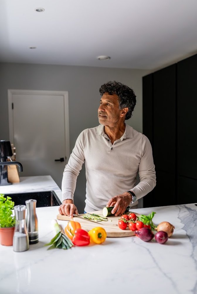 Persoon bereidt verse groenten in de keuken bij informatie over smaakverandering en voeding.