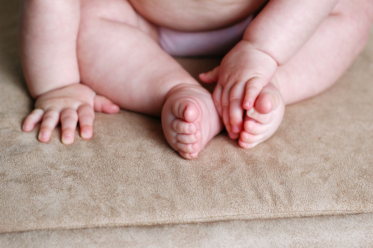 Closeup, color image of a chunky baby's little fingers and toes.
