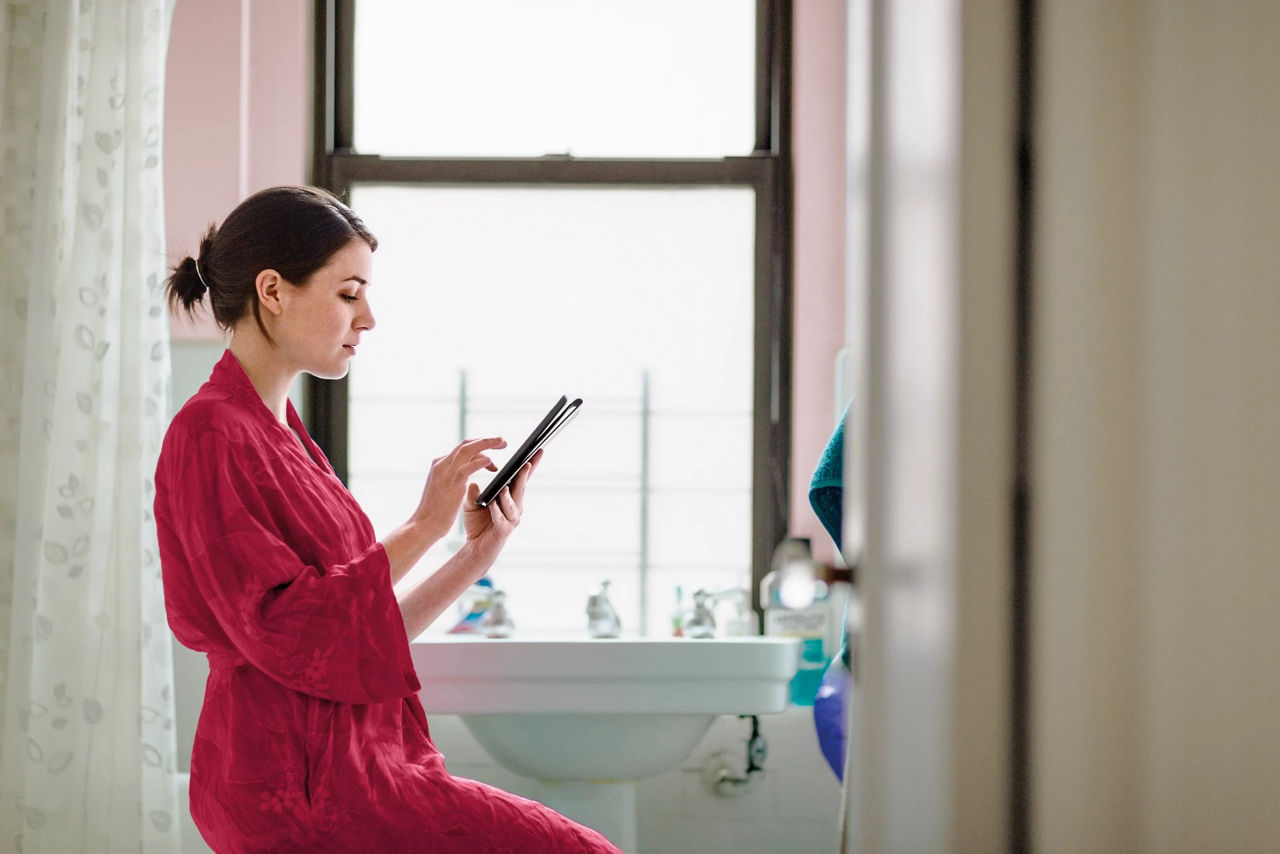 Woman in the bathroom on her tablet