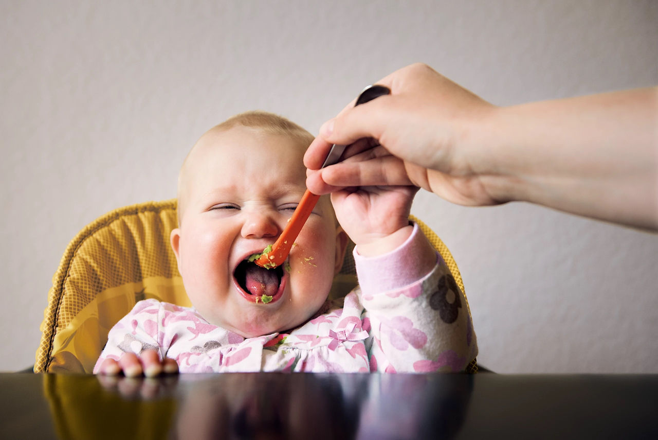 Mum spoon feeding baby