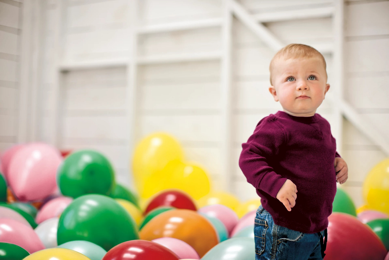 toddler with baloons