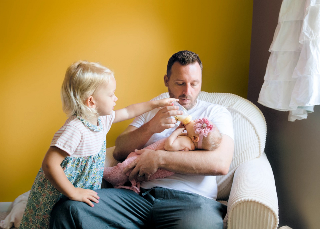 father bottle-feeding baby
