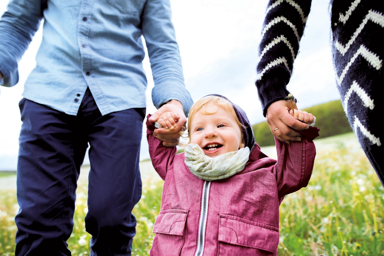baby walking with parents