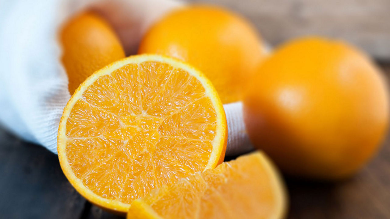 Primer plano de naranjas cortadas haciendo referencia a la Vitamina C en el embarazo: naranjas frescas como fuente natural de nutrientes esenciales para la madre y el bebé