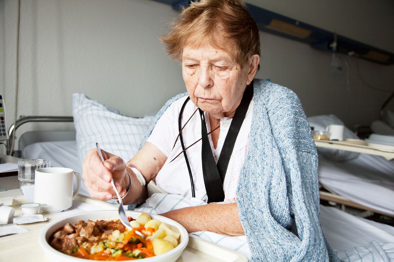 senior woman in hospital, eating, without good appetite