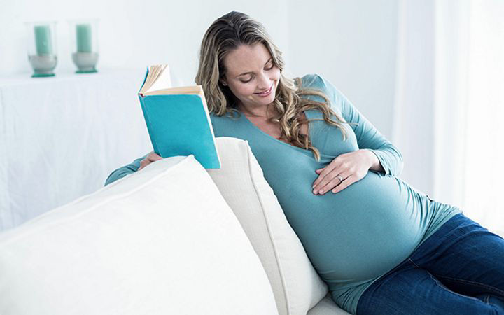 беременная женщина читает книгу