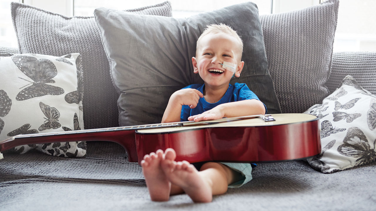 Pediatric happy boy with guitar image
