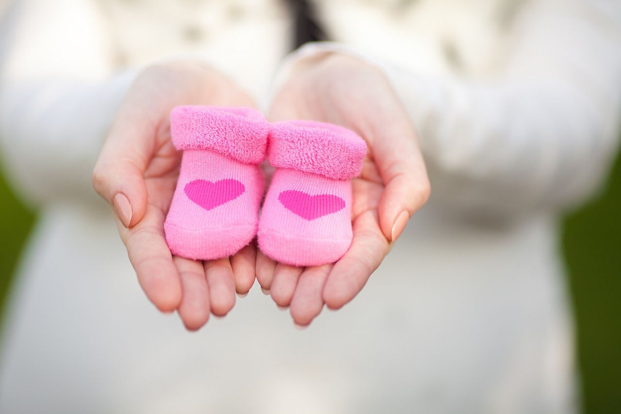 Pregnant woman belly holding pink baby booties, expecting girl. Healthy pregnancy. ; Shutterstock ID 169511642,pink baby booties held by mum