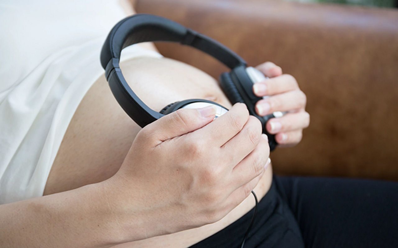 pregnant woman holding headphones on her belly. Music for baby. concept pregnancy  and music. Stock Photo