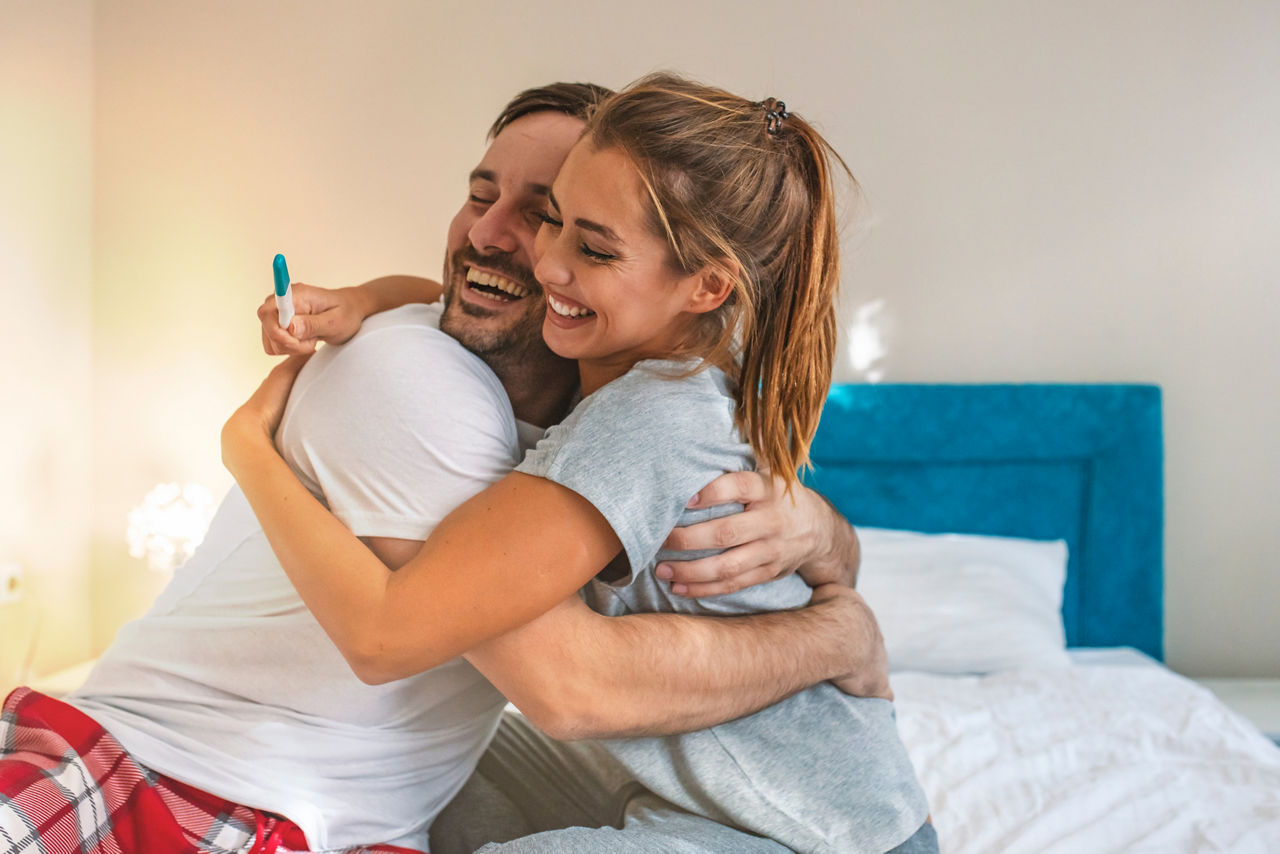 We become parents. Couple feeling happy after taking a home pregnancy test.  I'm pregnant! Happy young couple with pregnancy test. Joyful couple with positive pregnancy shown in the test device