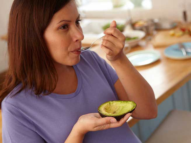 pregnant woman eating avocado