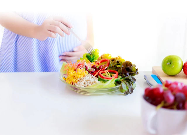 pregnant woman eating vegetables