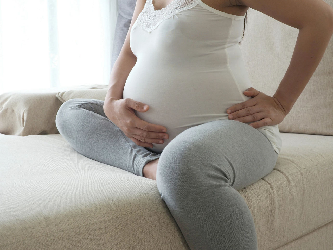 Pregnant woman feeling sick in living room