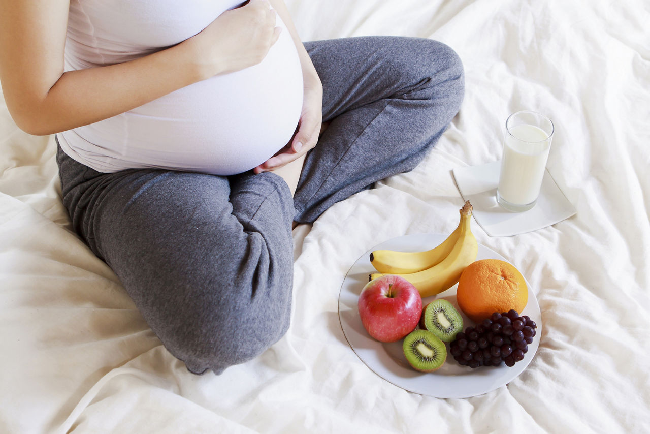 Nutritional needs during pregnancy found in milk and fruit; Shutterstock ID 199532300,pregnant woman beside fruit