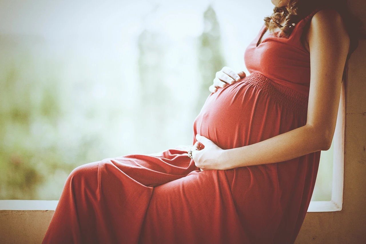 Pregnant woman holding belly