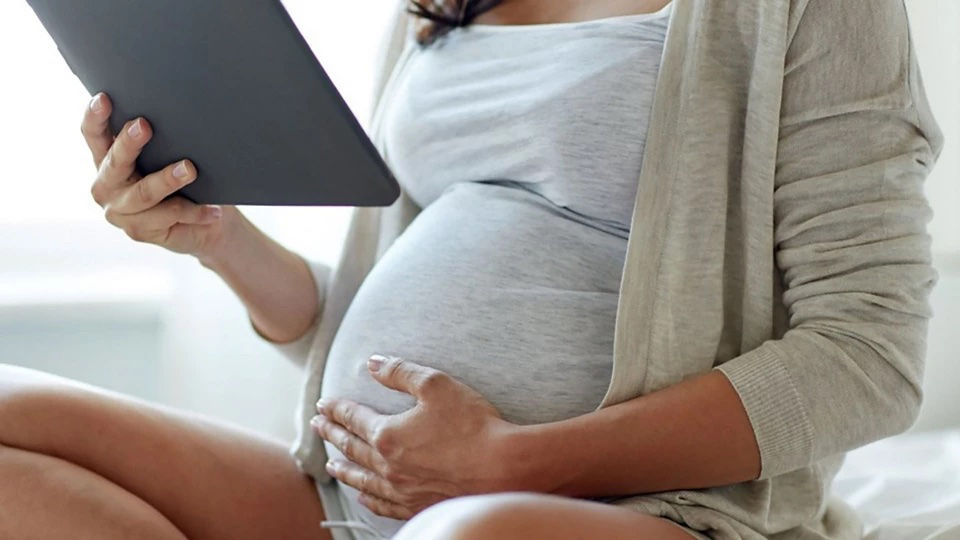 image of pregnant mum reading an ipad