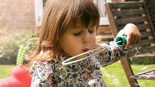 Little girl blowing bubbles