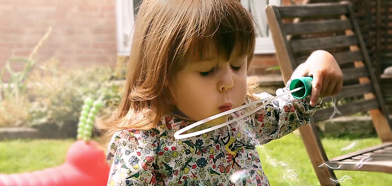 Little girl bowing bubbles