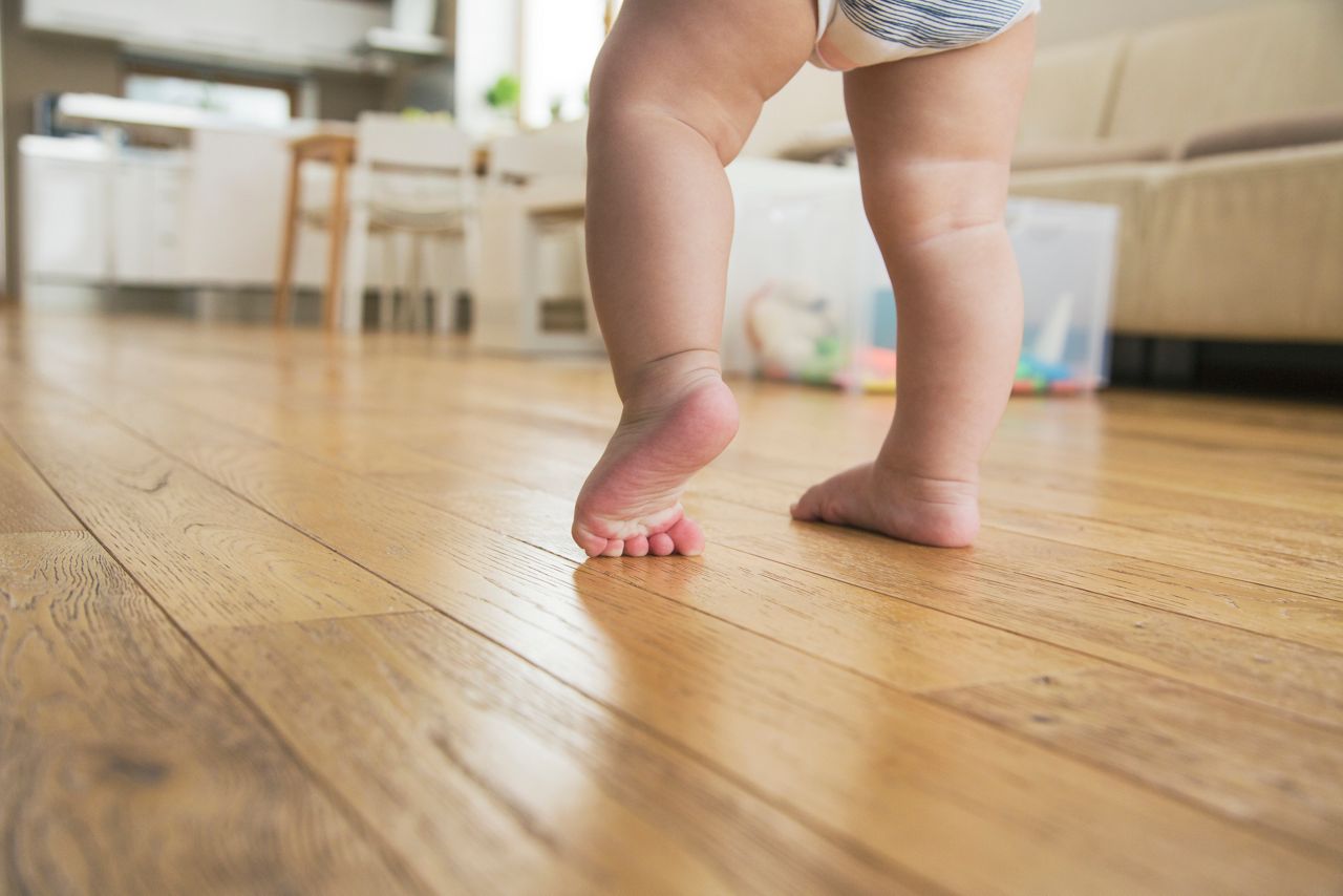 Pai ajuda o bebe a dar os primeiros passos