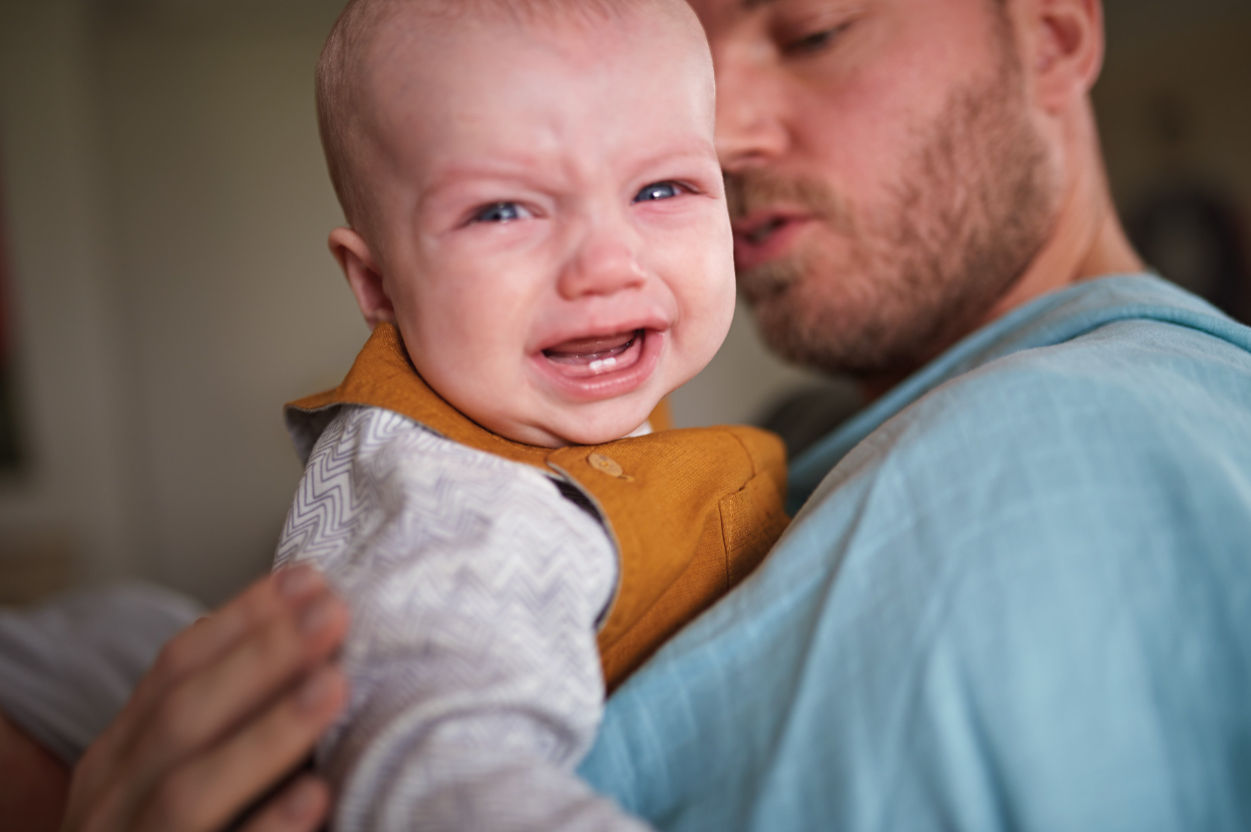 Baby crying in dad's arms