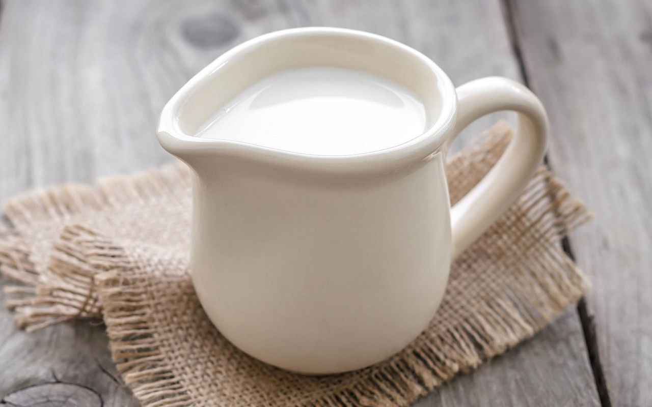 A jug of milk sitting on the table