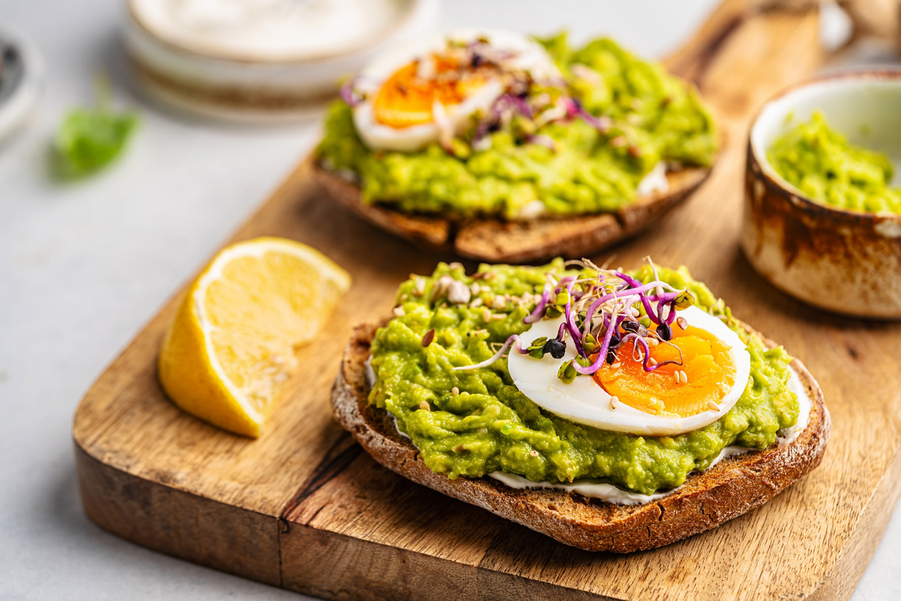 Toast with avocado, feta cheese, eggs, herbs and seeds with lemon slices on white background. Healthy eating and wholesome Breakfast; Shutterstock ID 2555976827; purchase_order: Achat articles alpro 2026; job: ; client: ; other: 