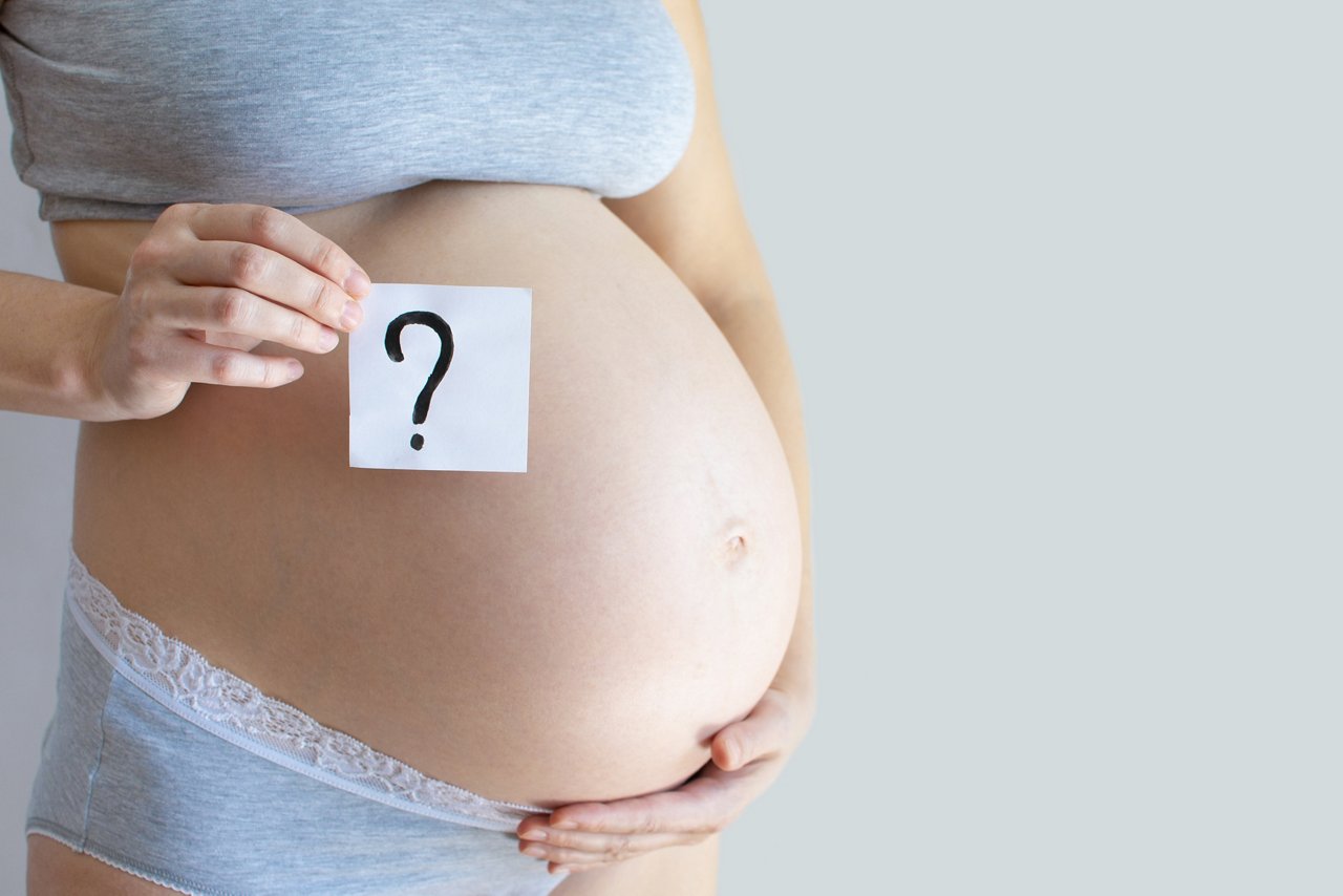 Close-up pregnant belly with question mark text. Concept to abort, toxicosis, problems of pregnant women, single mothers, AIDS and pregnancy, difficult pregnancy, motherhood, illness, anxiety getty images 1296681645