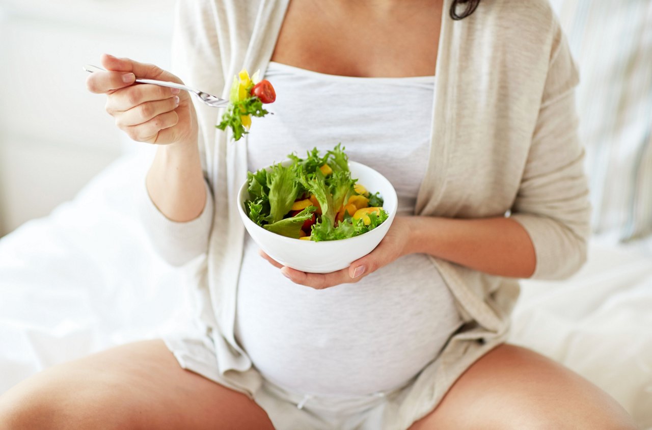 pregnancy, healthy food and people concept - close up of happy pregnant woman eating vegetable salad for breakfast in bed at home getty images 864581910