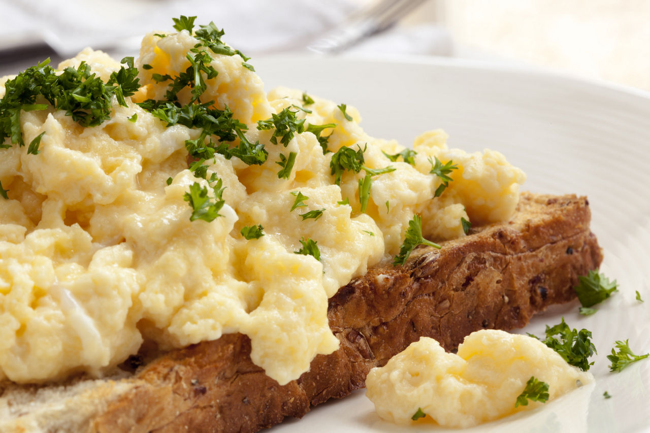 Scrambled eggs on toasted wholegrain bread.  Garnished with parsley.; Shutterstock ID 159975461,scrambled egg on toast