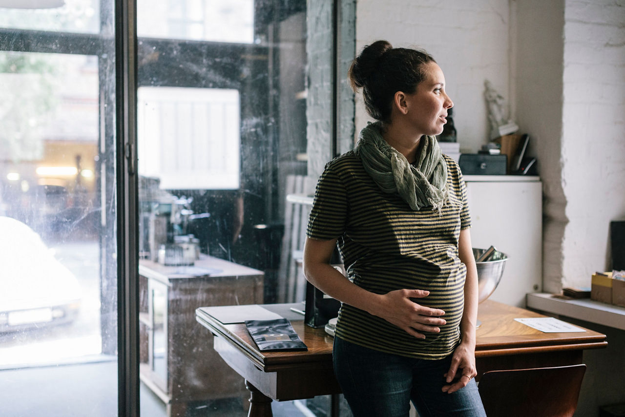Pregnant woman talking a break while working in Roastery