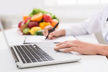 Nutritionist working on laptop and writing diet plan for patient, panorama, copy space; Shutterstock ID 1292011333; purchase_order: DNC Thumbnails; job: Webinars 1 (50/189); client: ; other: 