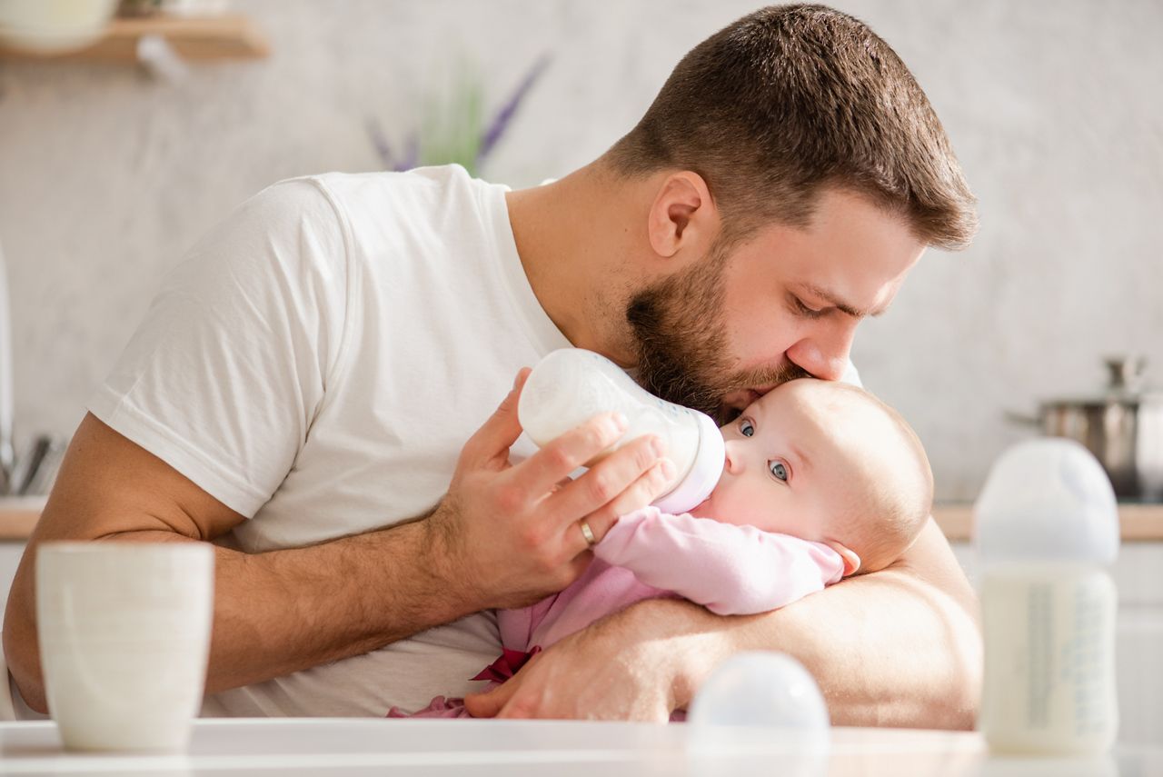 Young father kiss his baby during drinking milk; Shutterstock ID 1371456425; purchase_order: DNC Thumbnails; job: Publications; client: ; other: Replace Fishwife