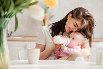 Feeding newborn girl with formula in a bottle.; Shutterstock ID 1371456440; purchase_order: DNC Thumbnails; job: Webinars 2 (50/188); client: ; other: 
